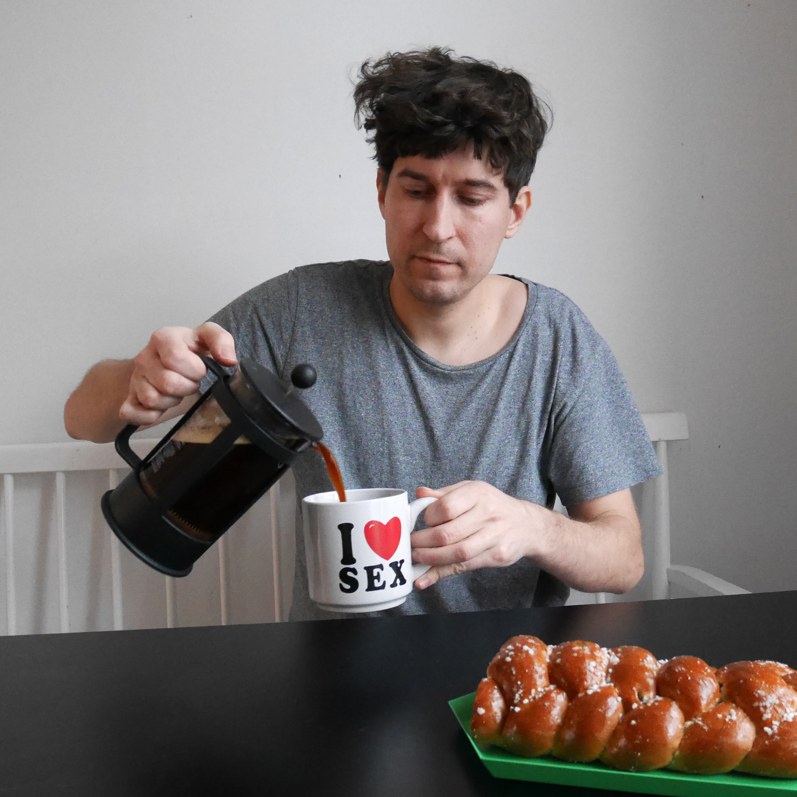 Kasper Strömman kaataa kahvia mukiin, jossa lukee "I sydän SEX".