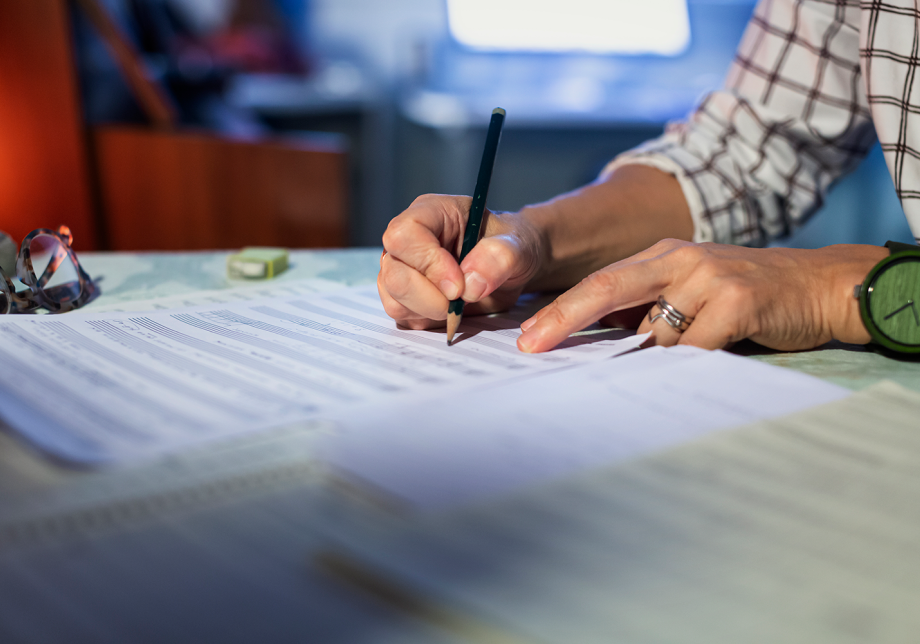 Lähikuva säveltäjän käsistä kirjoittamassa nuotteja paperille.