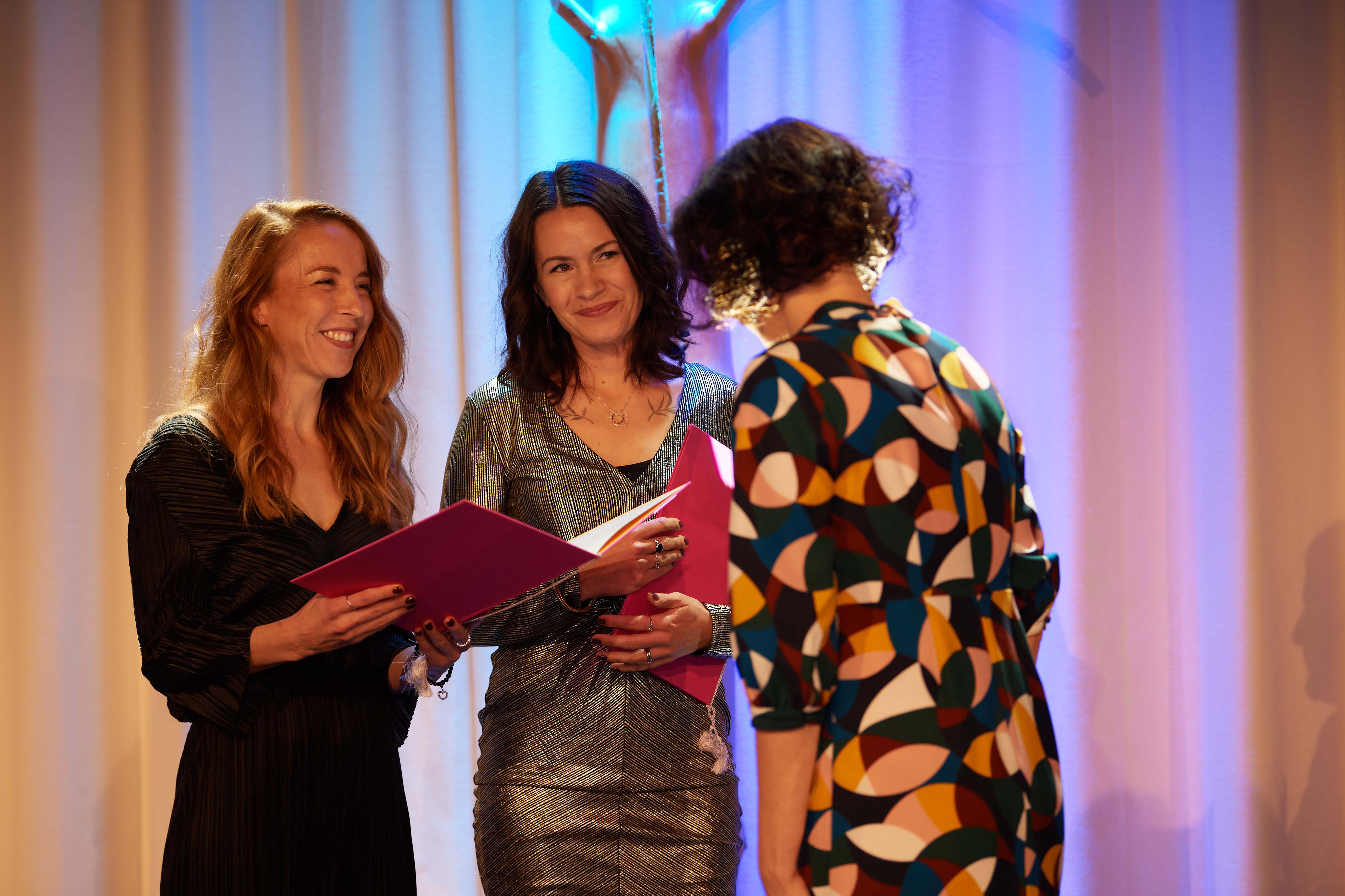 Alexandra Mangs ja Annika Åman seisovat palkintokirjat käsissään Jenni Haukion edessä.