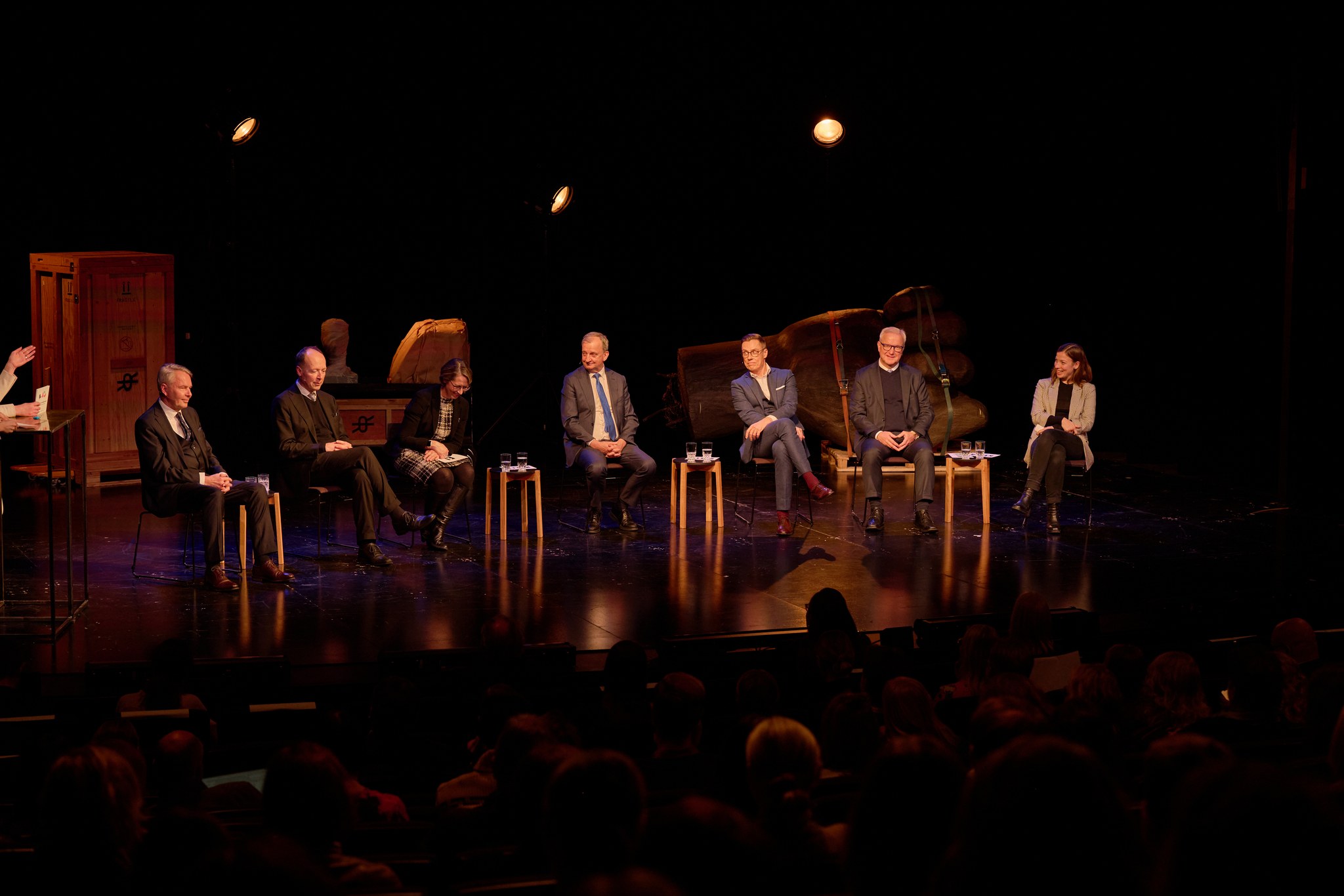 Presidentkandidaterna sitter på stolar på scenen.