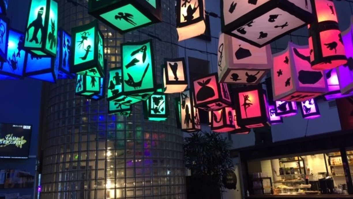 Kulttuuritalon katossa roikkuvia värikkäitä paperilyhtyjä, joissa on mustia eläin-, kasvi- ja olioaiheisia siluetteja.