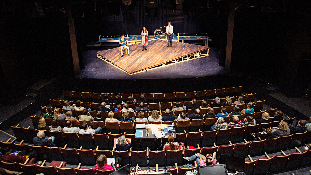 Näyttelijät harjoittelevat teatterin lavalla esitystä.
