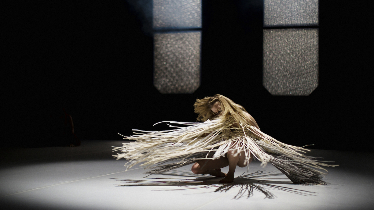 Tanssija keskellä pyörivää liikettä.