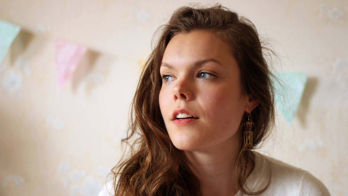 Henkilö hymyilee ja katsoo oikealle päin.