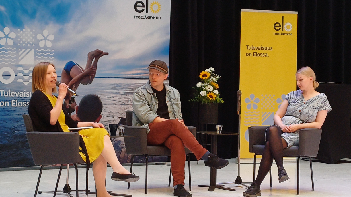 Tilaisuuden keskustelijat lavalla.