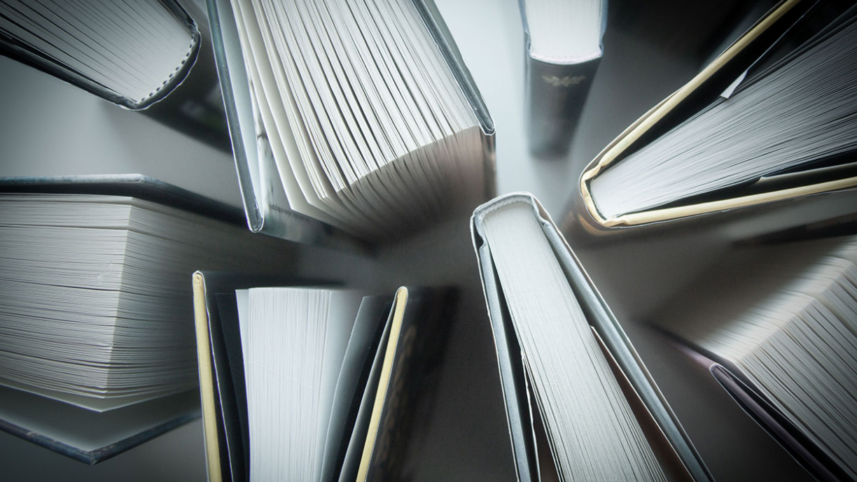 Pystyyn aseteltuja kirjoja kuvattuna ylhäältä päin. 