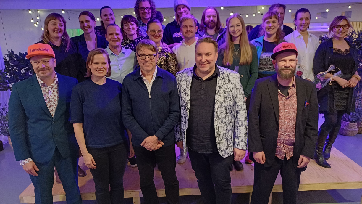 Iloinen joukko rahoitettuja tekijöitä ryhmäkuvassa yhdessä raadin kanssa