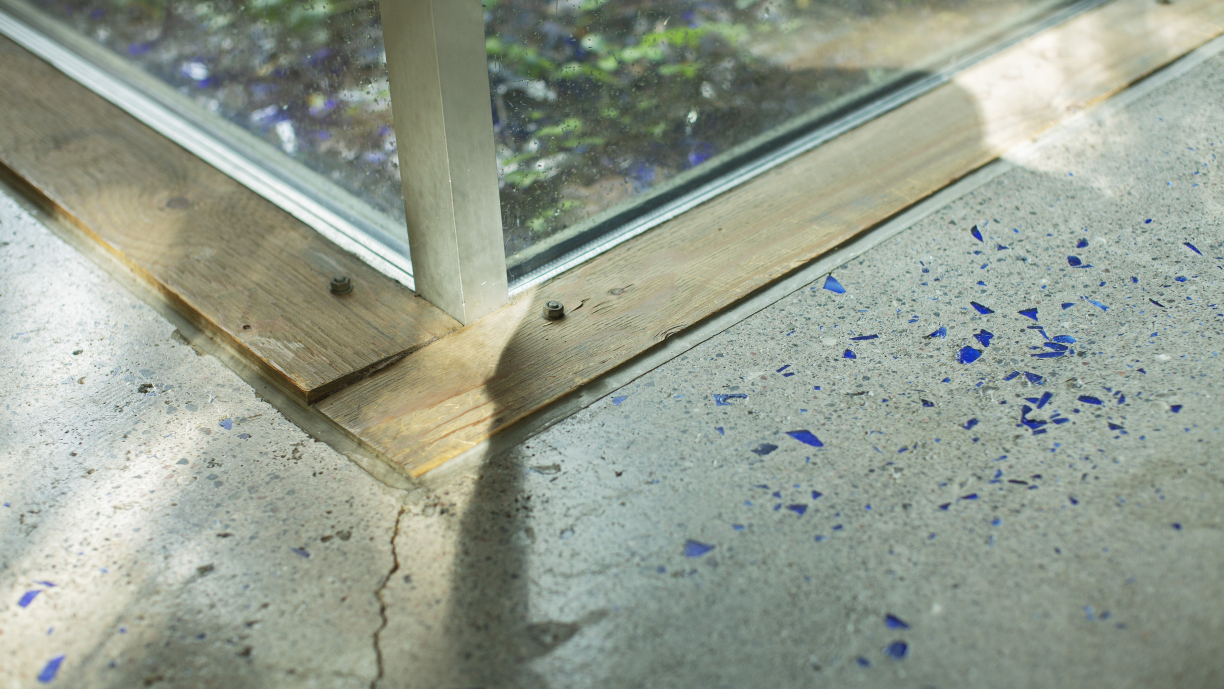 Sinivalkoinen lattian kulma ja hieman ikkunaa, joka ulottuu lattiaan