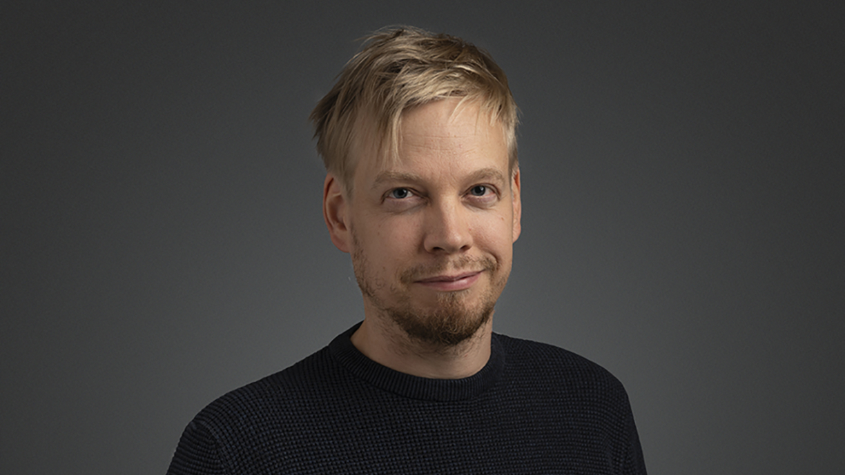 Antti Huntuksen puolilähikuva tummaa taustaa vasten