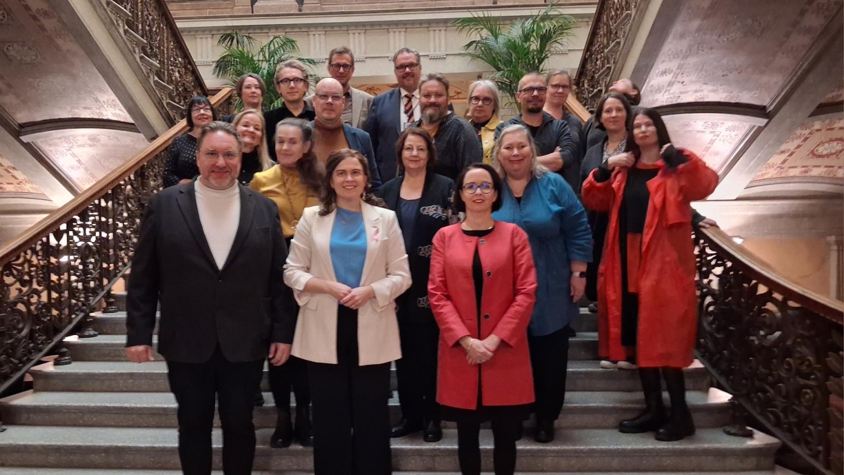 Taide- ja kulttuurineuvoston jäsenet sekä ministeri Talvitie ja ylijohtaja Rintamäki seisovat Säätytalolla portaikossa ryhmäkuvassa