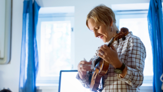 Säveltäjä soittaa melodiaa viululla näppäillen.