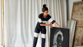 Nykytaiteilija järjestelee teoksiaan.