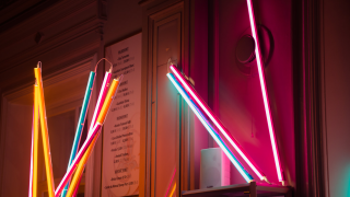 Eri värisiä valokeppejä seinää vasten.