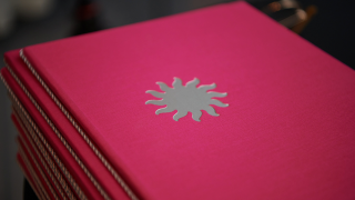 Lähikuva valtionpalkintojen kunniakirjapinosta.