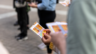 Lähikuva käsistä, jotka pitelevät kaupungin karttaa. 