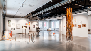 Näyttelytila, jonka seinillä on taidetta.