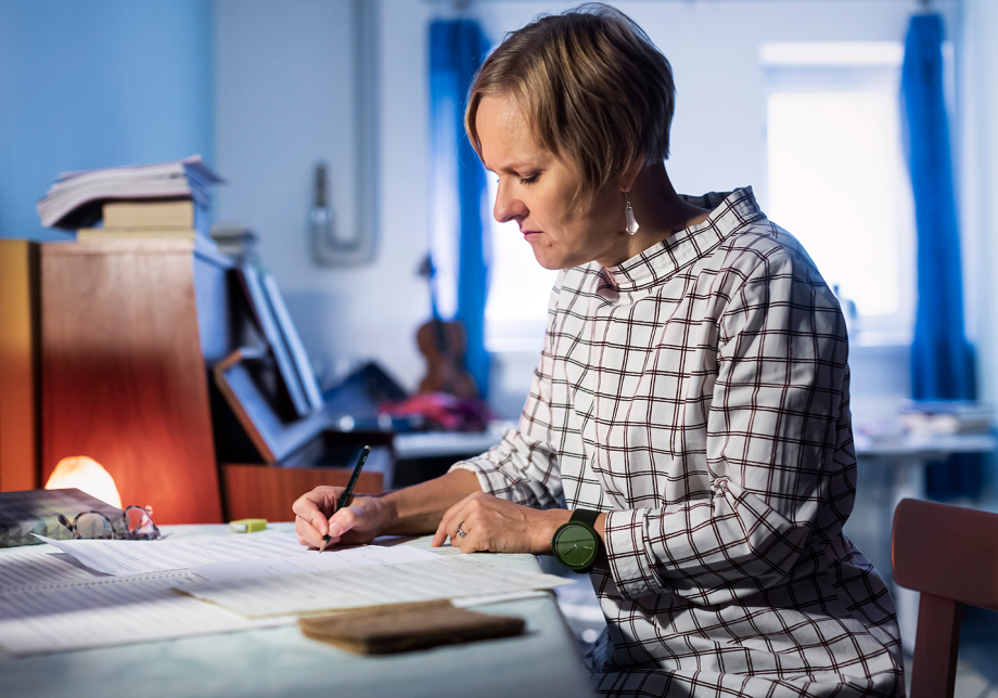 Säveltäjä kirjoittaa nuotteja paperille.