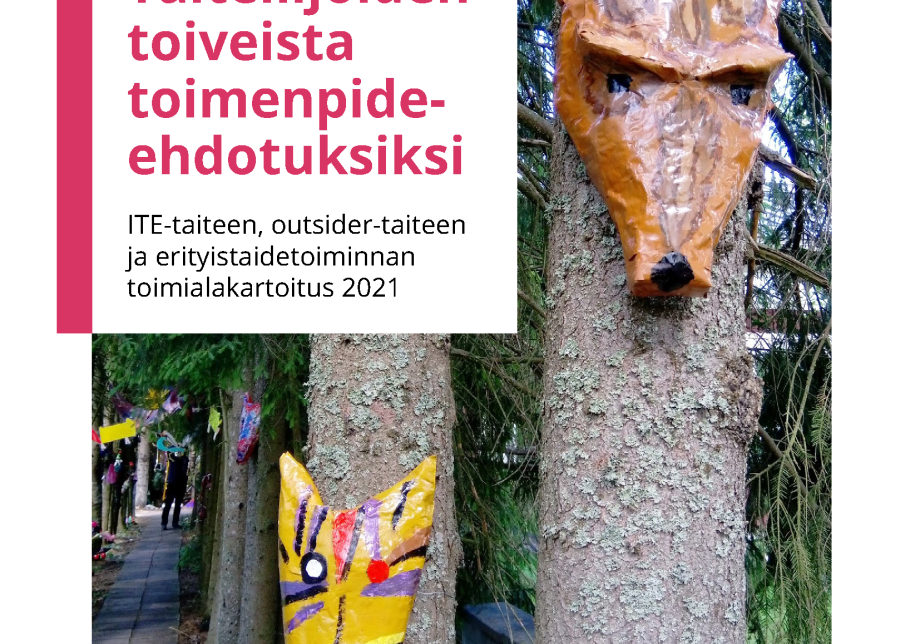 Kuja, jota reunustaa rivi kuusia. Kahden kuusen runkoon on kiinnitetty kissan ja ketun kasvoja muistuttavat naamiot.