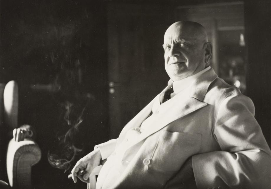 Jean Sibelius istuu tuolilla ja hymyilee