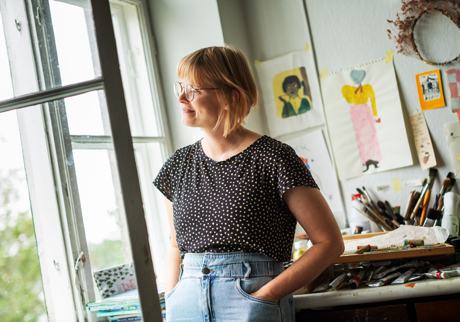 Kuvittaja katsoo ulos ikkunasta työhuoneellaan