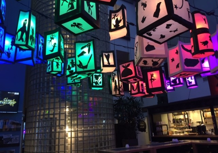 Kulttuuritalon katossa roikkuvia värikkäitä paperilyhtyjä, joissa on mustia eläin-, kasvi- ja olioaiheisia siluetteja.