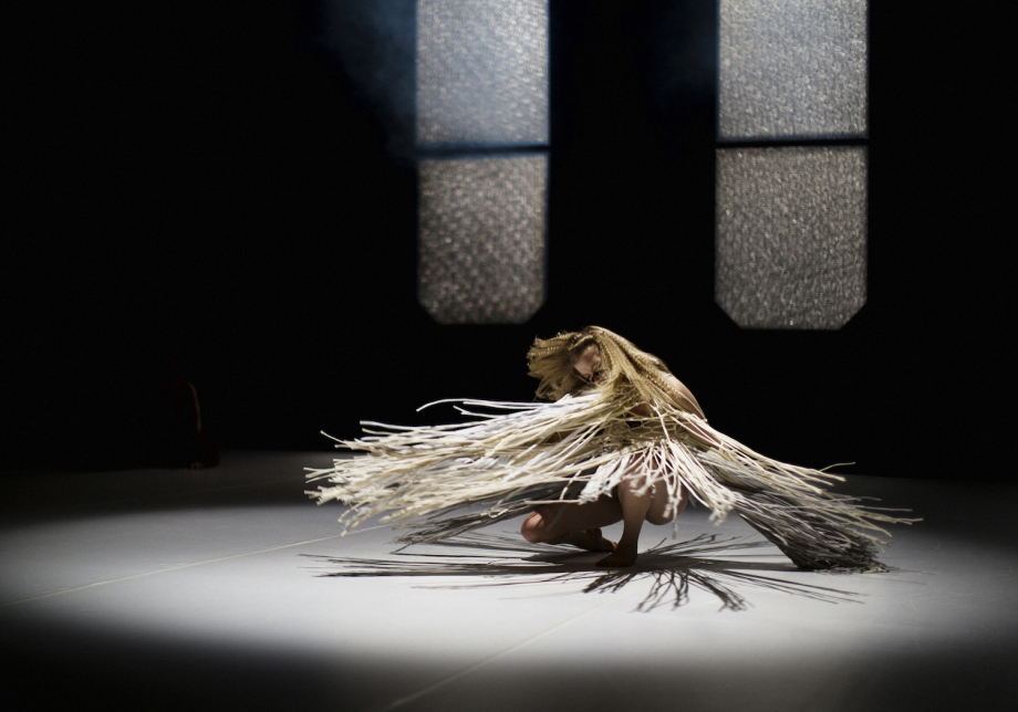 Tanssija keskellä pyörivää liikettä.