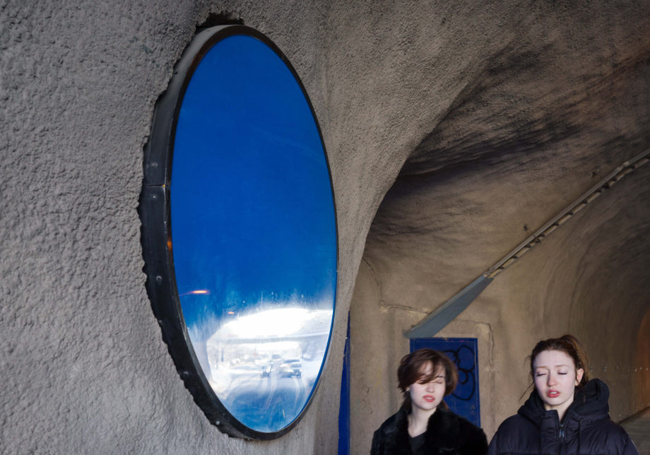 Kaksi henkilöä kävelee seinämässä olevan julkisen taideteoksen ohi.