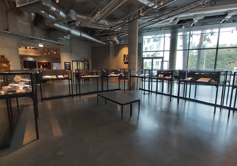 Näkymä museon näyttelytilaan, jossa näkyy vitriinejä ja taustalla iso ikkuna.