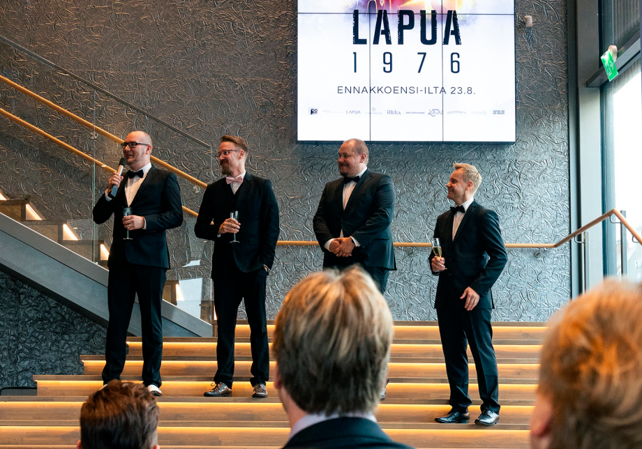 Neljä ihmistä seisoo elokuvateatterin rappusilla yleisön edessä ja yksi puhuu mikrofoniin.