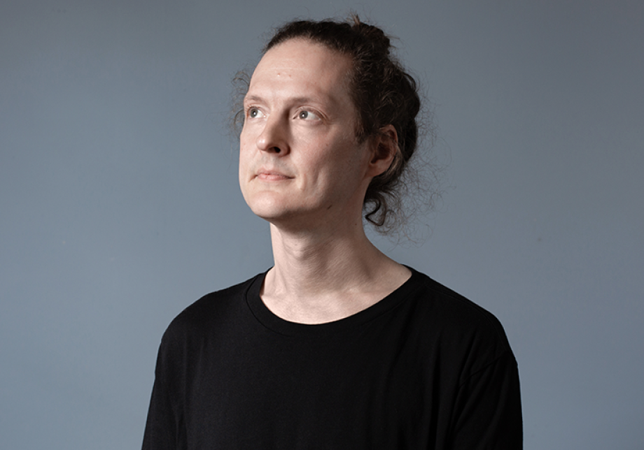 Antti Tolvi katosoo ylös päin harmaan seinän edessä.