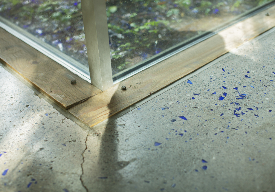 Sinivalkoinen lattian kulma ja hieman ikkunaa, joka ulottuu lattiaan