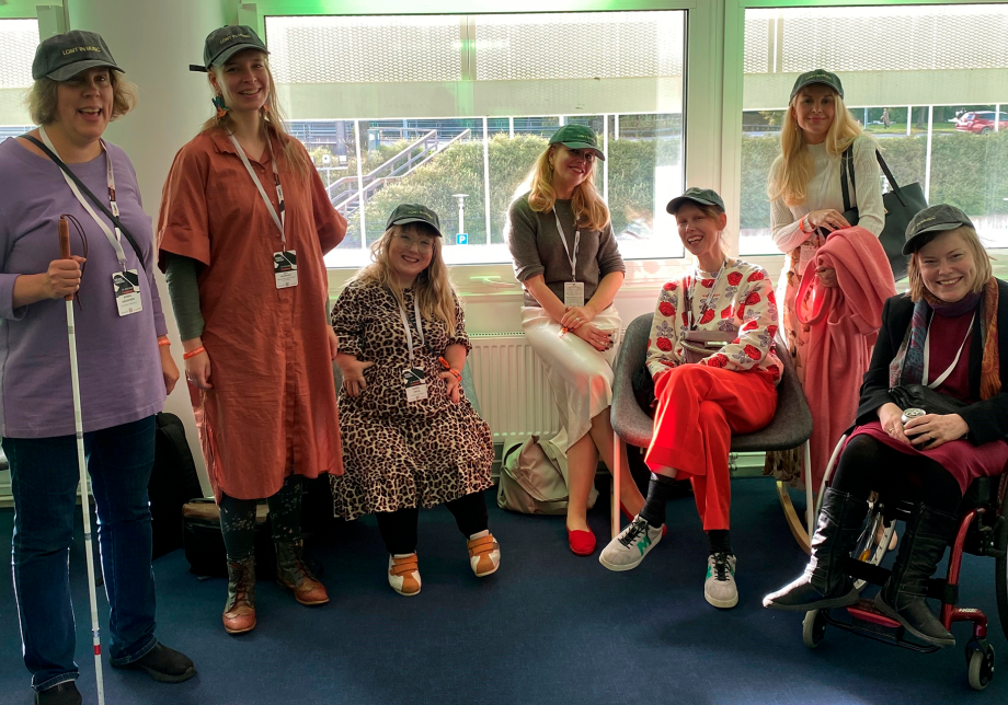 Ihmisiä ikkunan edessä katsomassa kameraan.