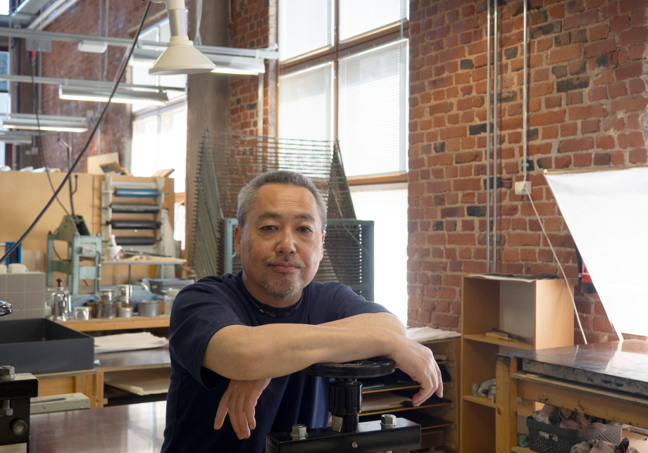 Naoji Ishiyama istuu työhuoneessaan ja katsoo kameraan.