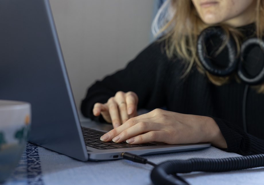 Kädet tietokoneen näppäimistöllä.