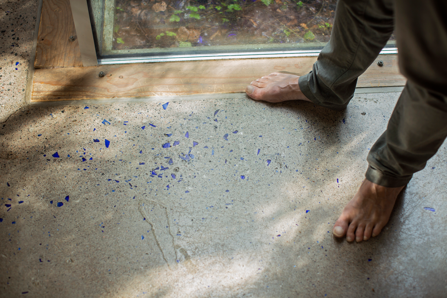 Arkkitehti paljain jaloin kivilattialla