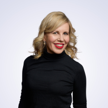 Hymyilevä kasvokuva Kaisa Rönköstä vaalealla yksivärisellä taustalla