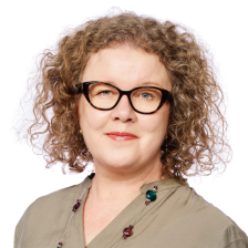 Kasvokuva Taina Laitisesta valkoisella taustalla. Taina hymyilee. 